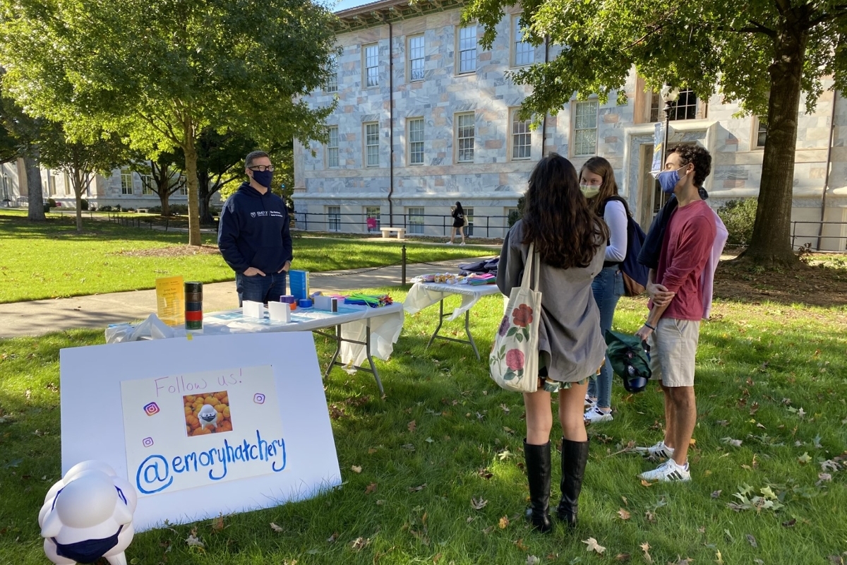 Hatchery sign up table set up outside with students standing around it 