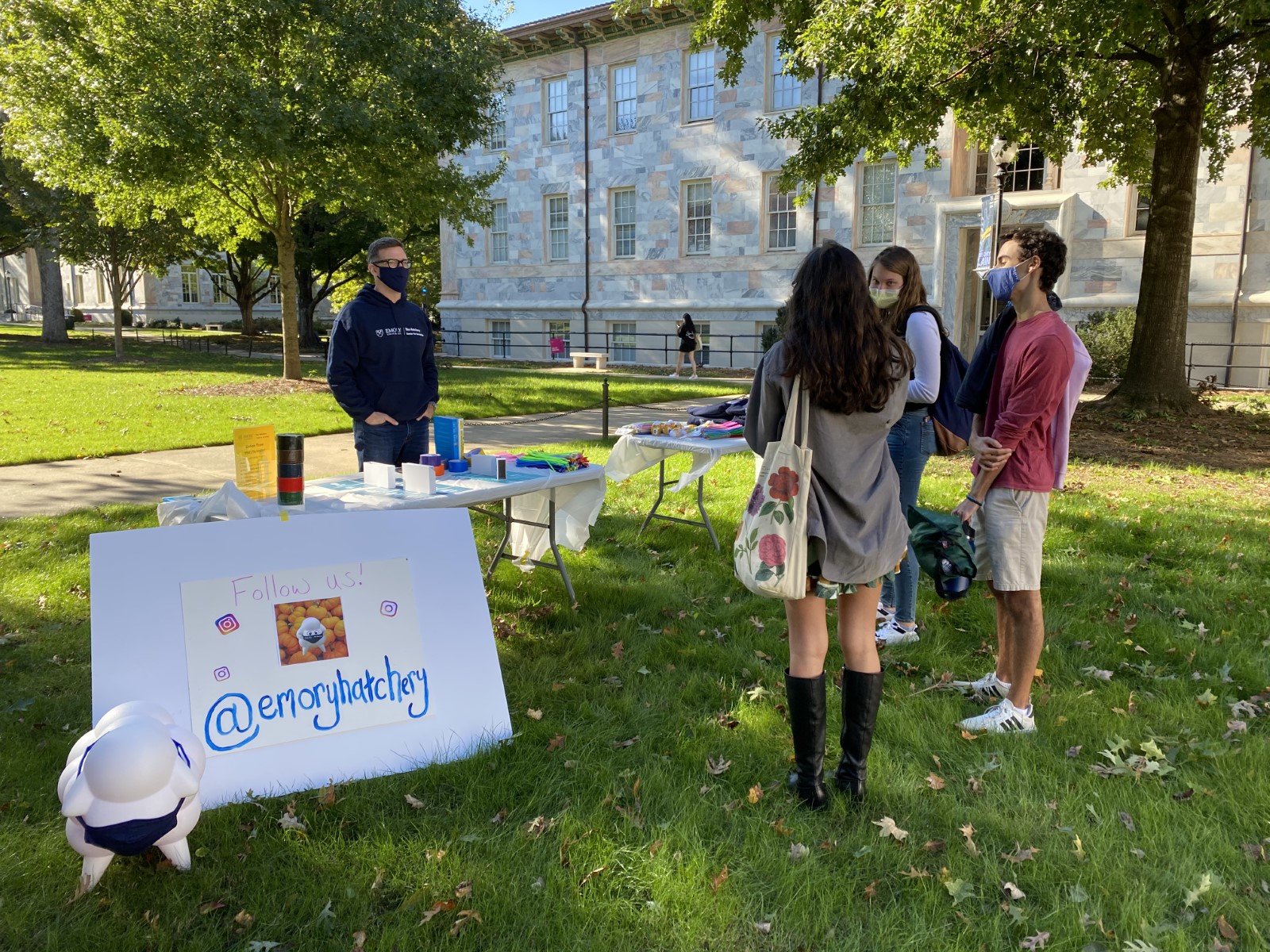 Hatchery sign up table on the lawn outside with students around it