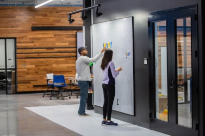 Two students working on a white board in the Hatchery.