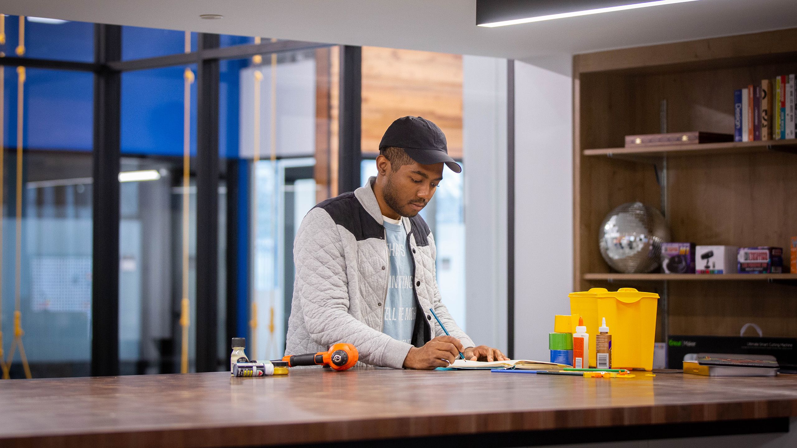 young man looking down and working at a wooden counter
