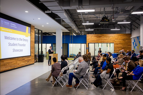 side view of a room full of people watching a projected presentation for the Student Founder showcase